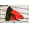 Medium dark orange crochet carrot pouch with dark green top  unfilled and untied to see. Tie can be tightened and secured.